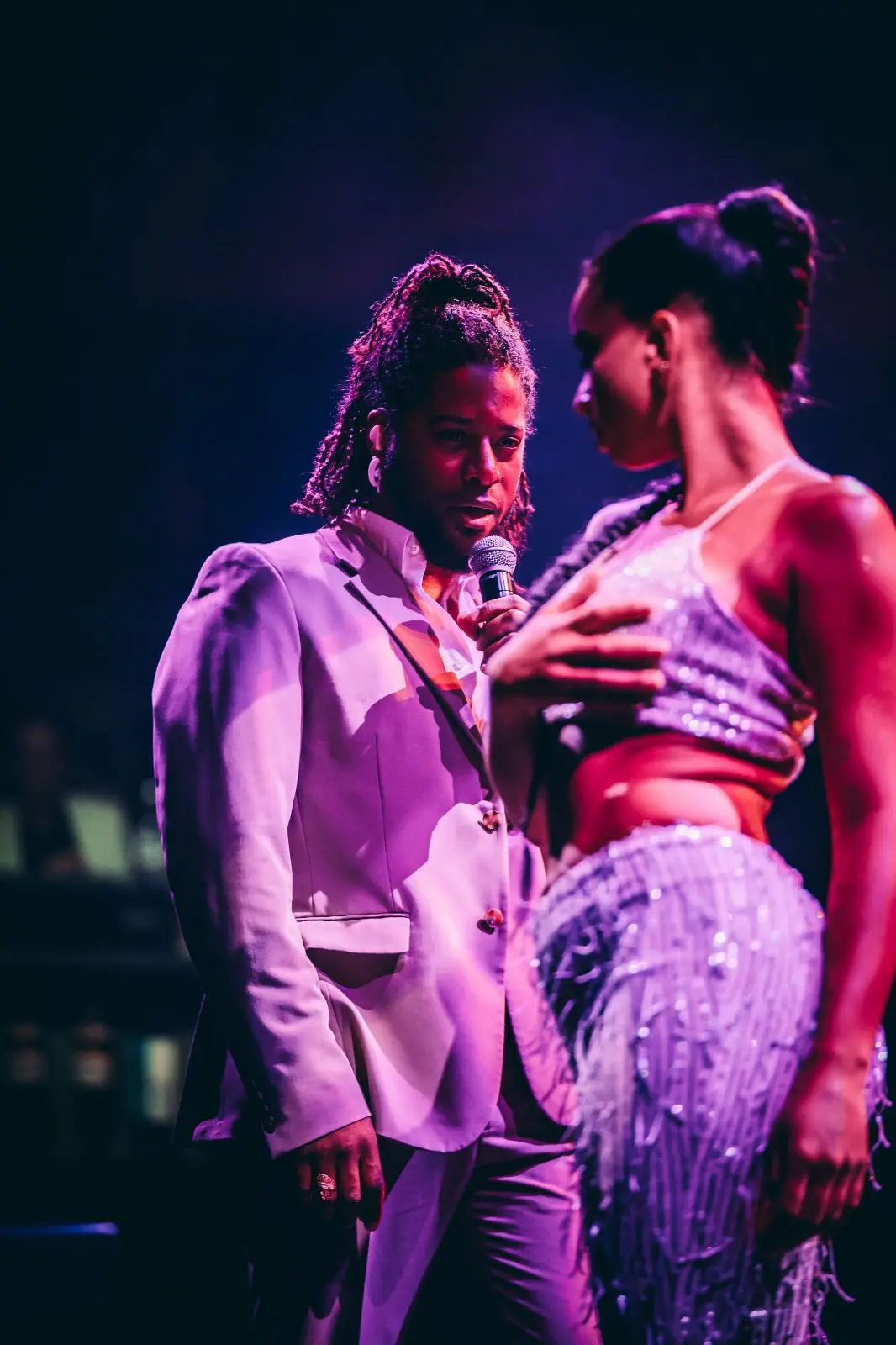 Zanger Omri Alpha tijdens een optreden met een paarse gloed over hem heen