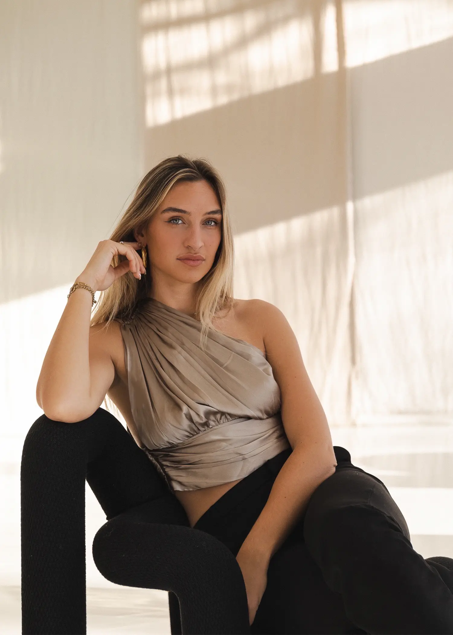 Sam Cordes zangeres zit op een stoel bij een fotoshoot