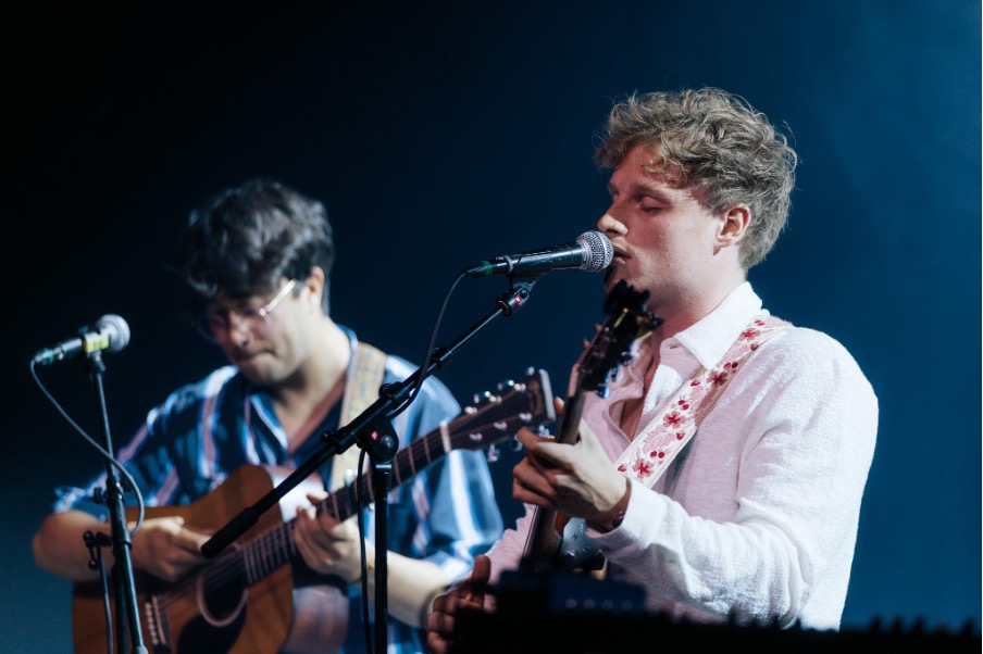 Simon Benedict Deliefdesliedjes zingt met een microfoon in z'n hand